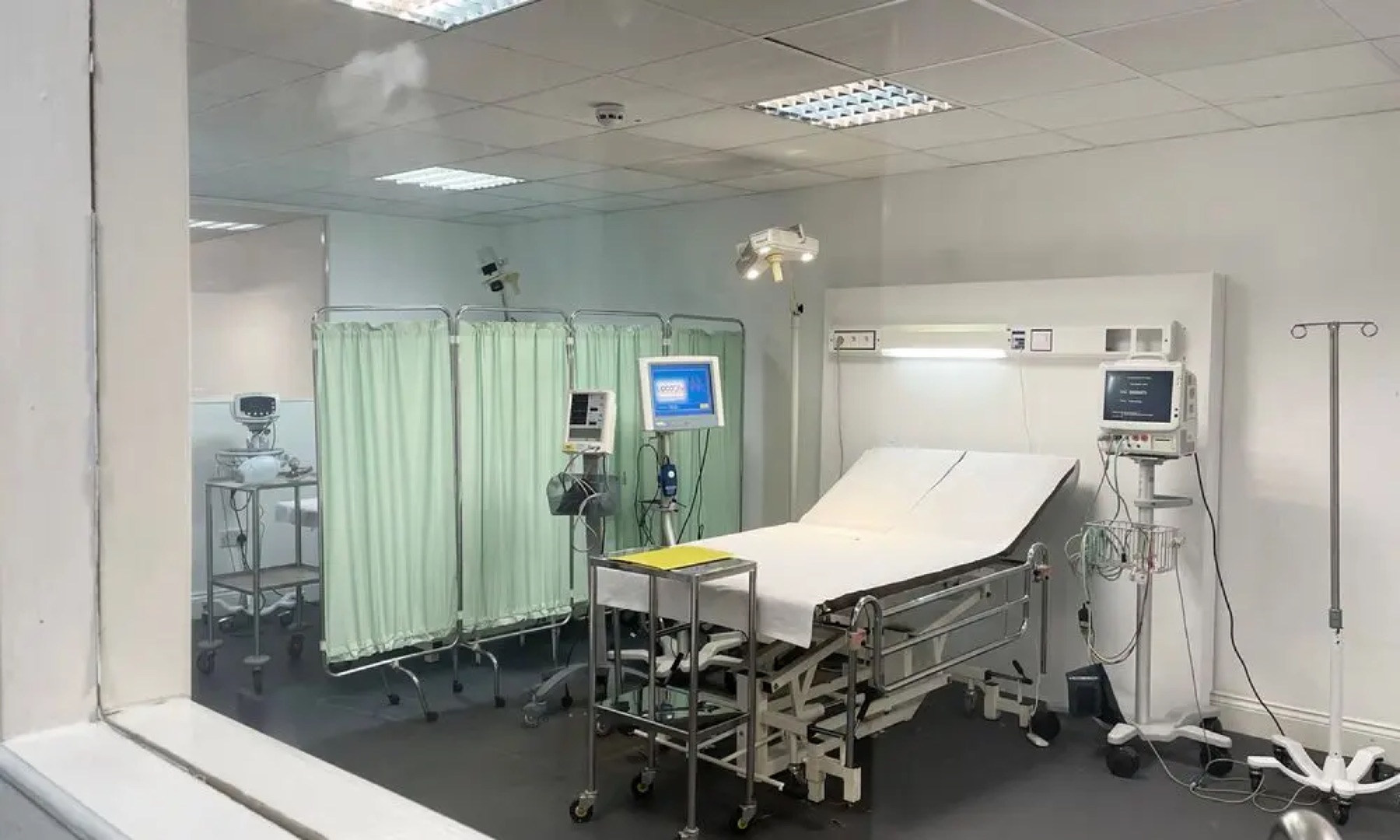 Clinical treatment room with bed and medical equipment