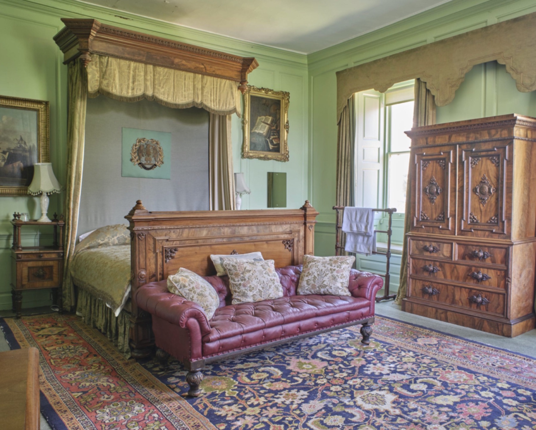 Green period bedroom with carved wood furniture