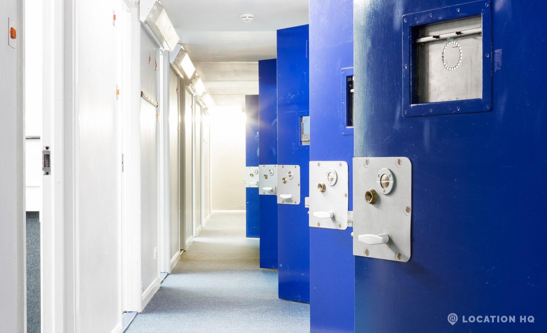 Contemporary institutional cell corridor with blue doors