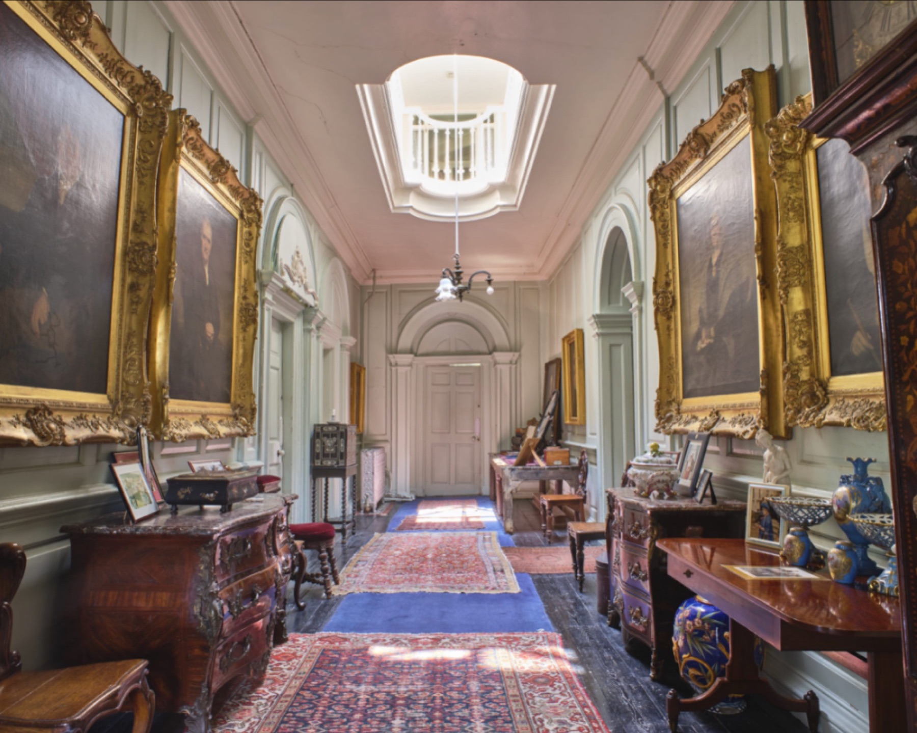 Long period hallway lined with portraits