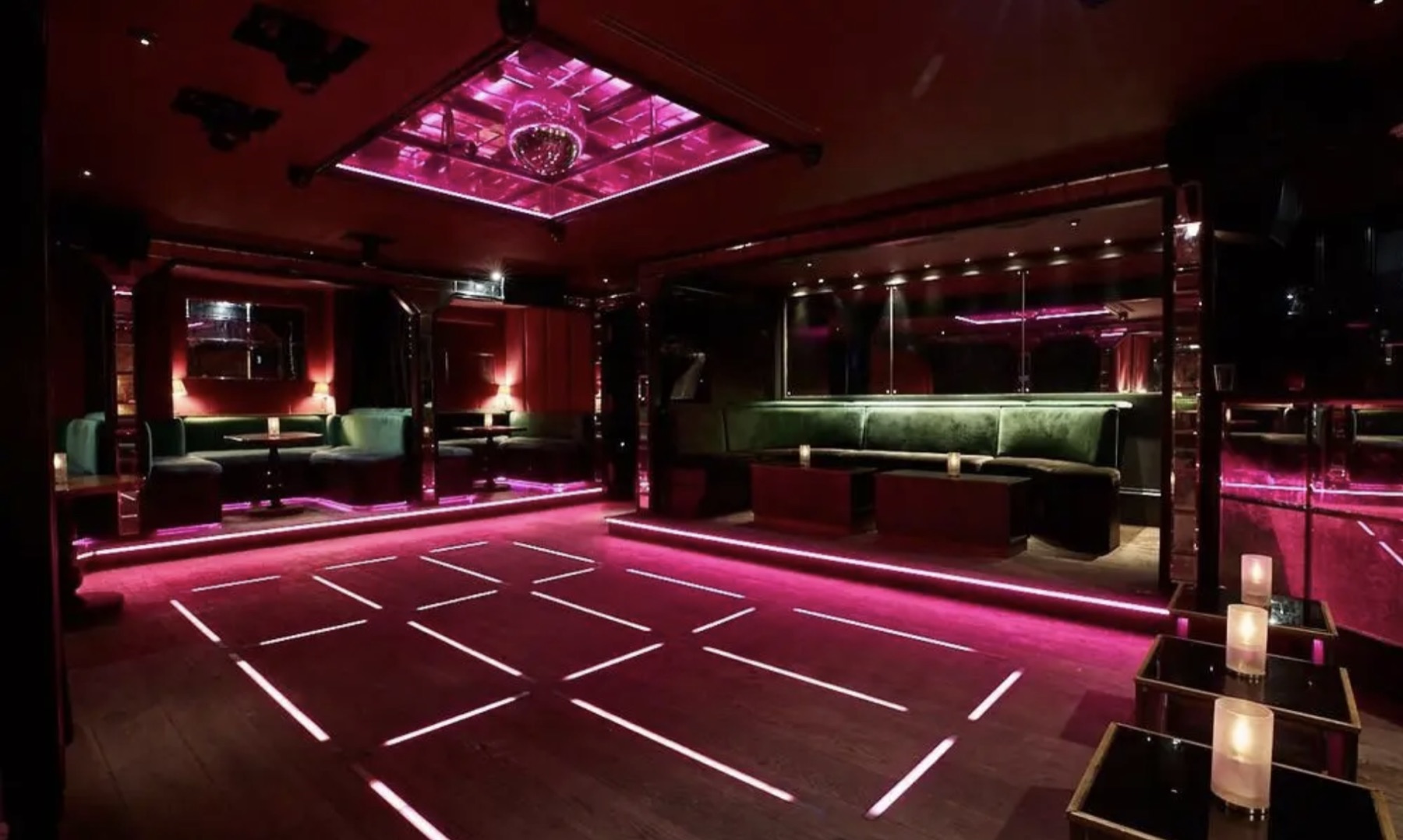 Red nightclub interior with mirrored walls and illuminated dance floor
