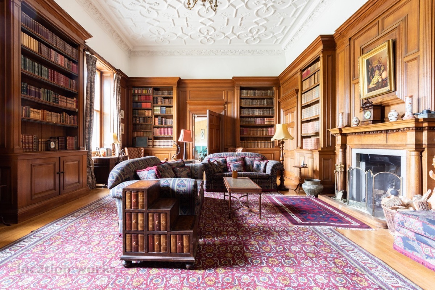 Wood-panelled library with fireplace and bookshelves